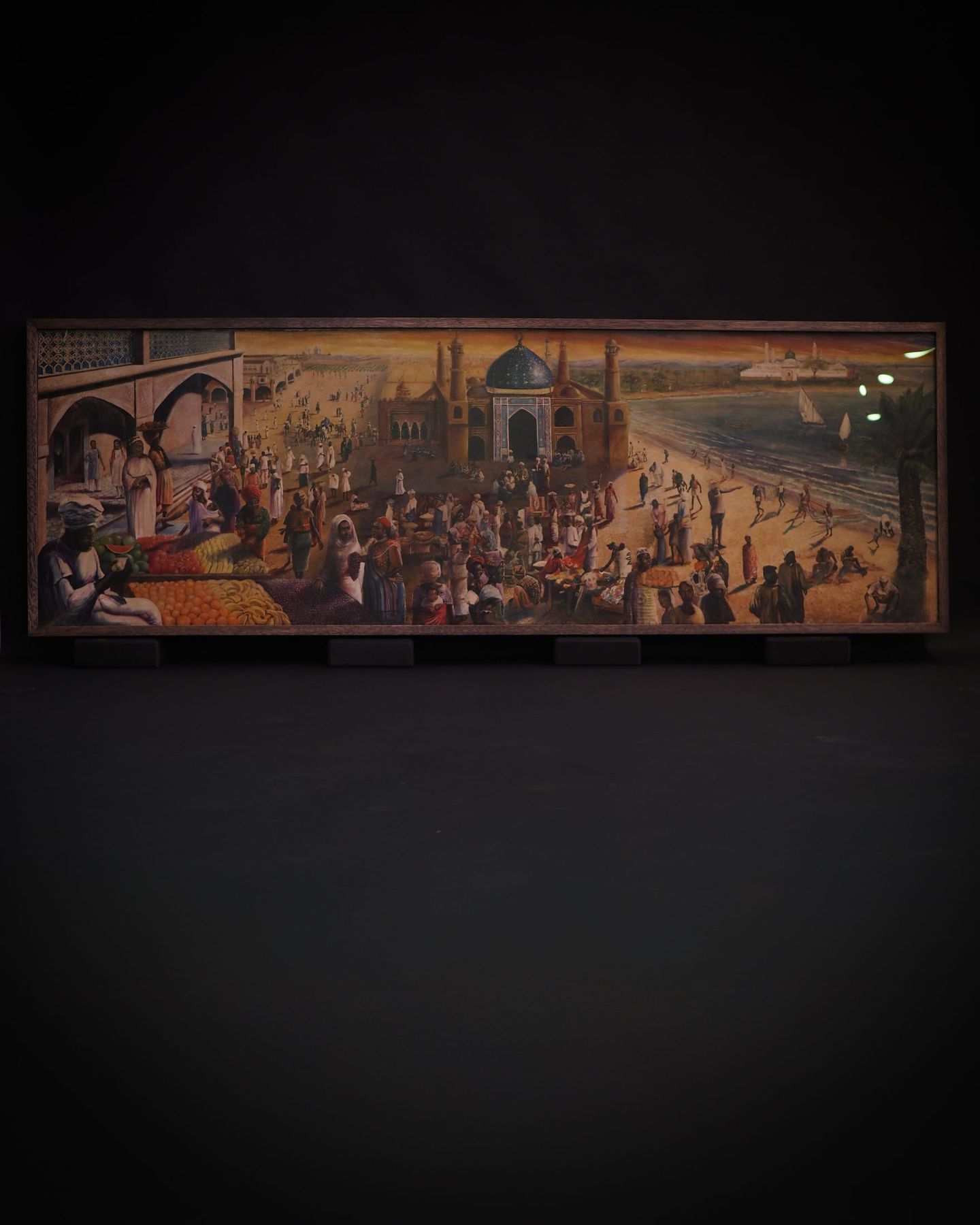Panoramic painting in a brown oak frame, photographed against black