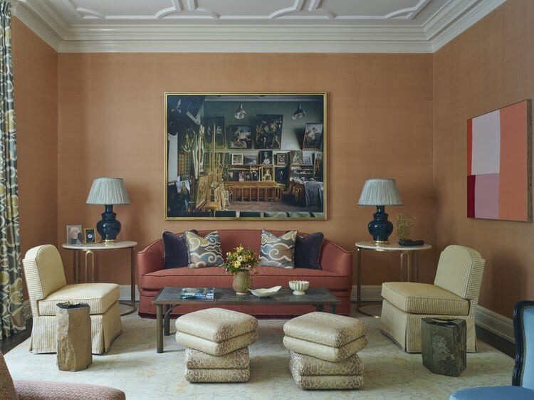Salon wall with paintings above a red sofa in a collector's residence, framing by SBAS Houston