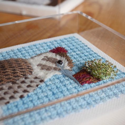 Handmade embroidery in an acrylic box with custom fabric-wrapped deck, SBAS Houston