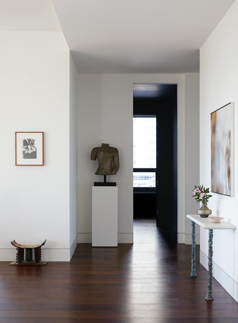 Minimal gallery hall with framed works and sculpture pedestal, SBAS Houston
