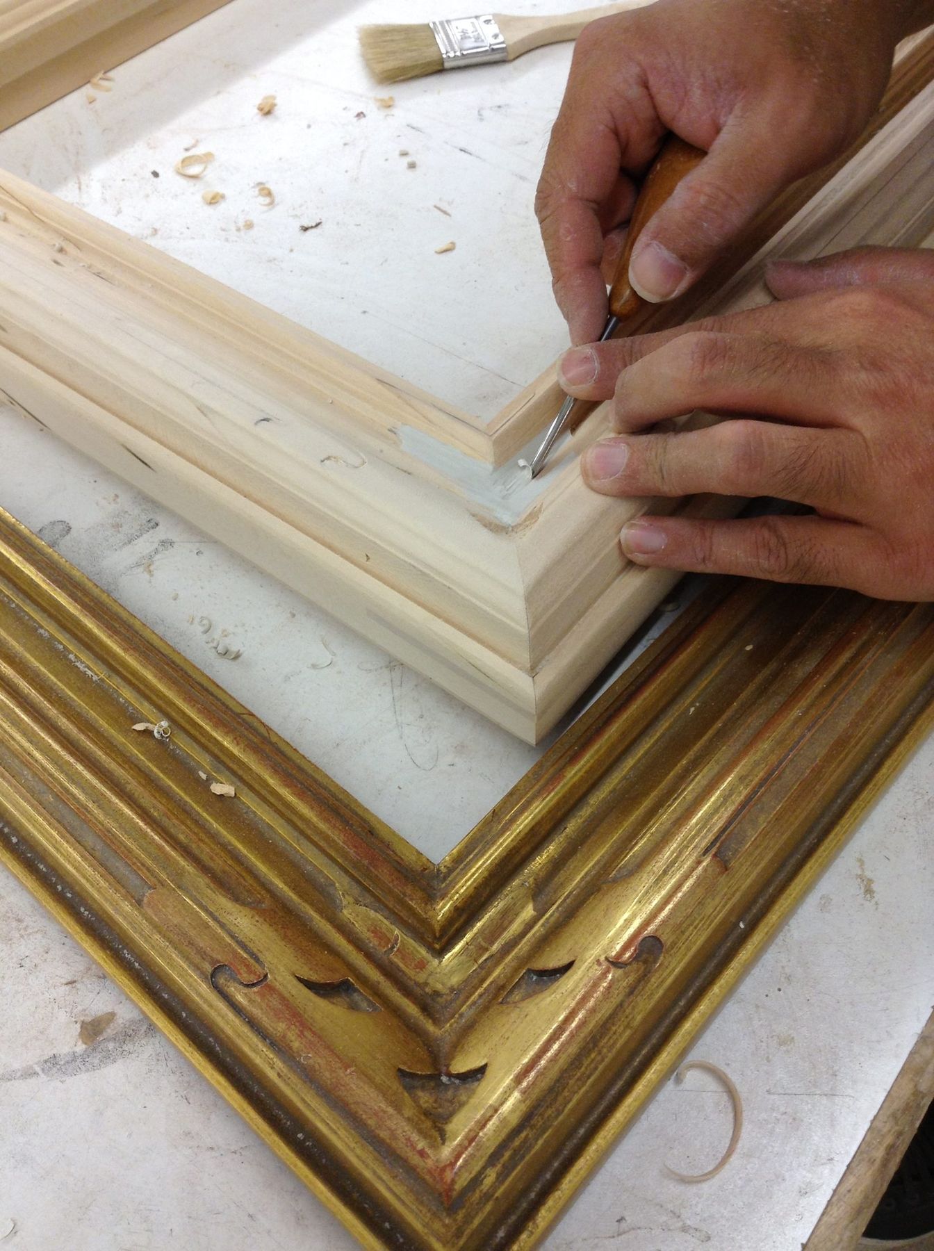Framemaker carving a period frame replica in the SBAS Houston studio