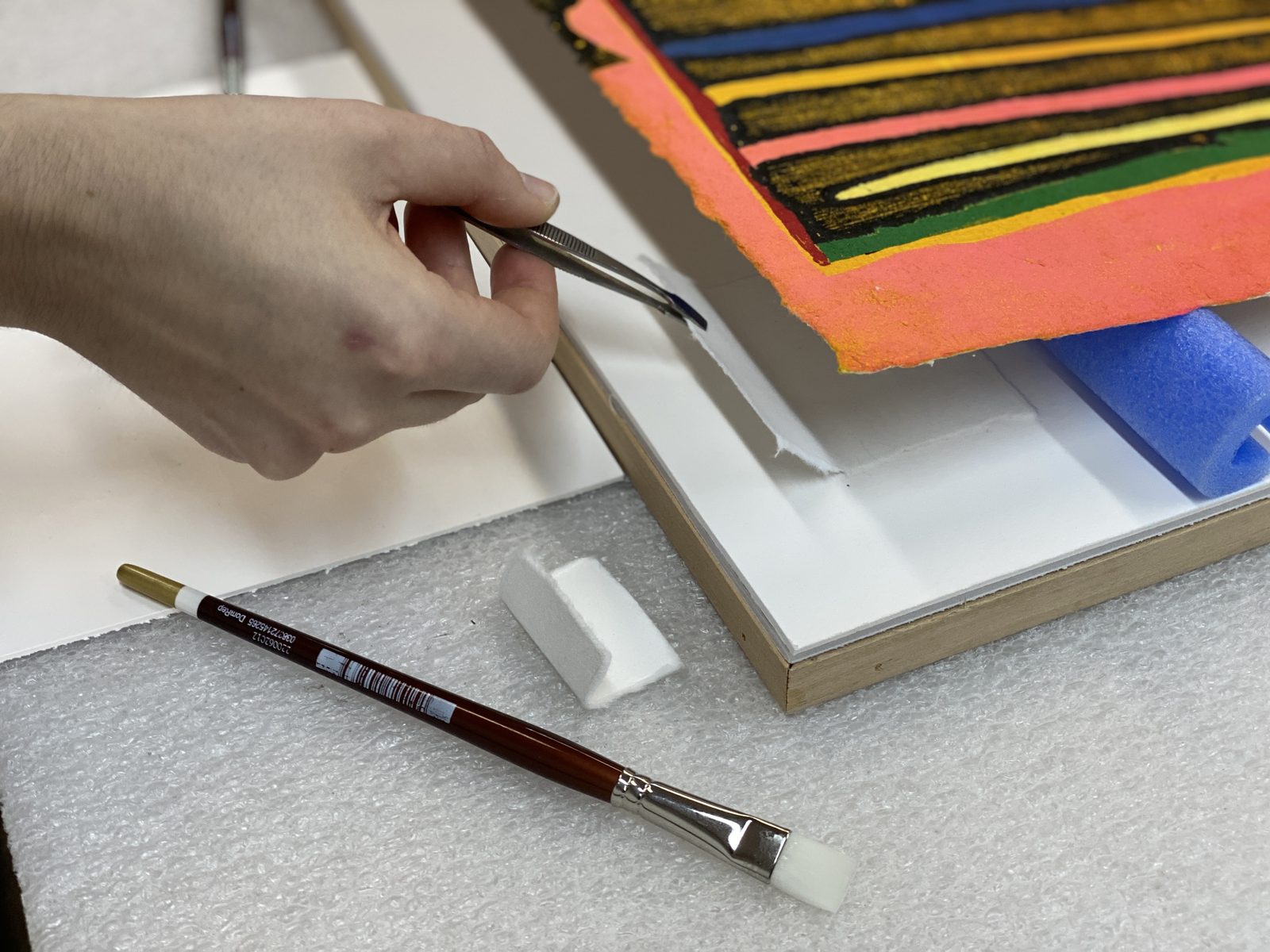 Fitter working archival mats at the SBAS preservation bench, Houston