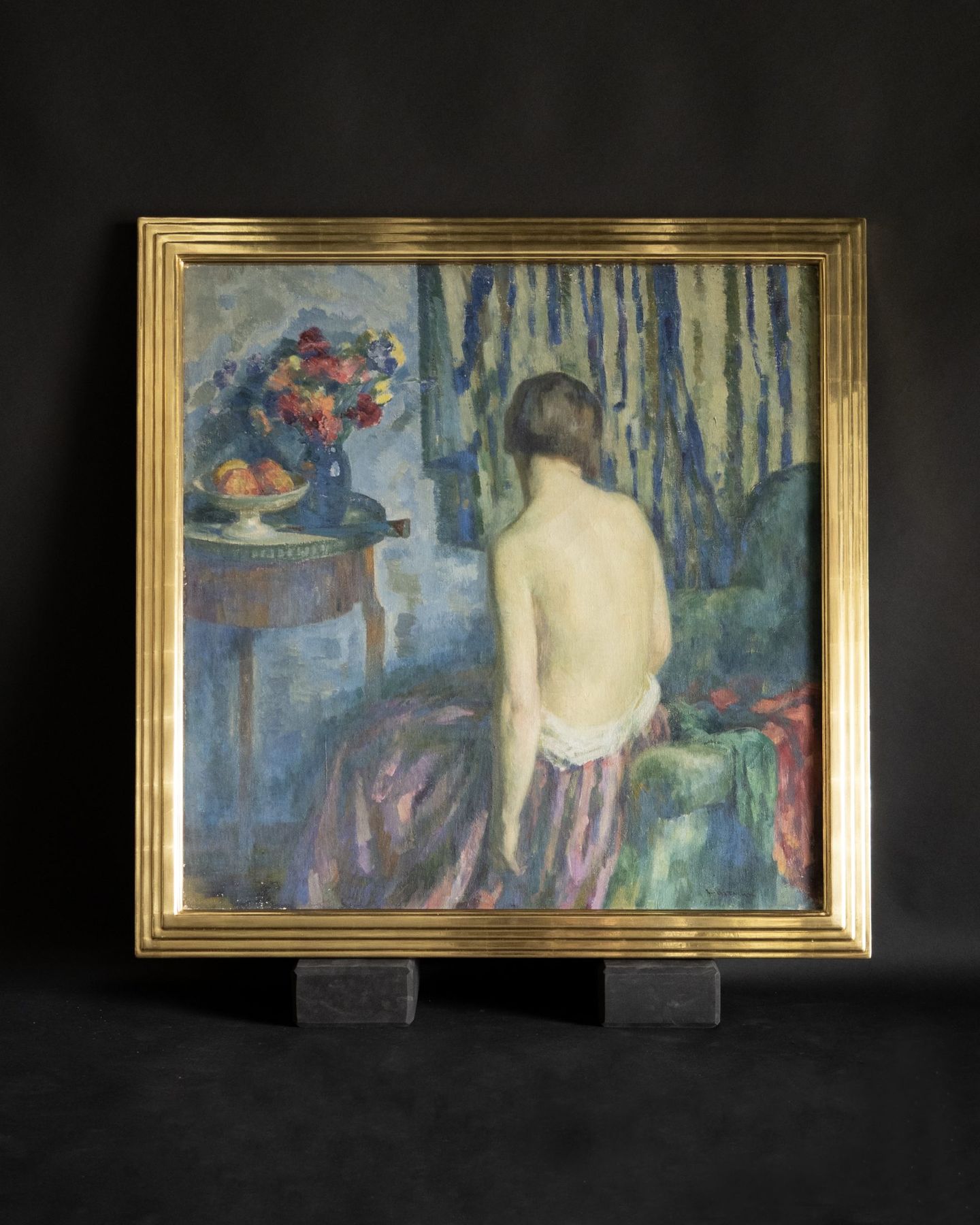 Figure painting in a stepped, water-gilded gold leaf frame photographed in raking light