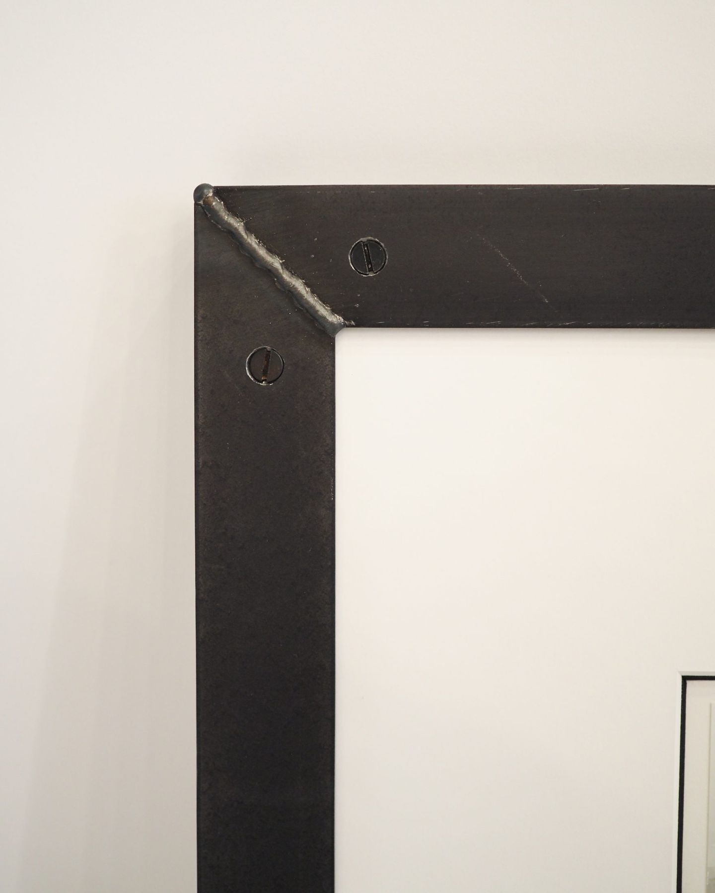Fused corner of a raw steel frame showing the ground seam, SBAS Houston